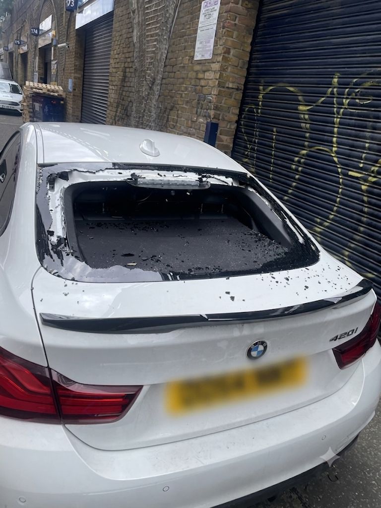 BMW 4 Series rear windscreen completely shattered with glass fragments scattered across the boot lid